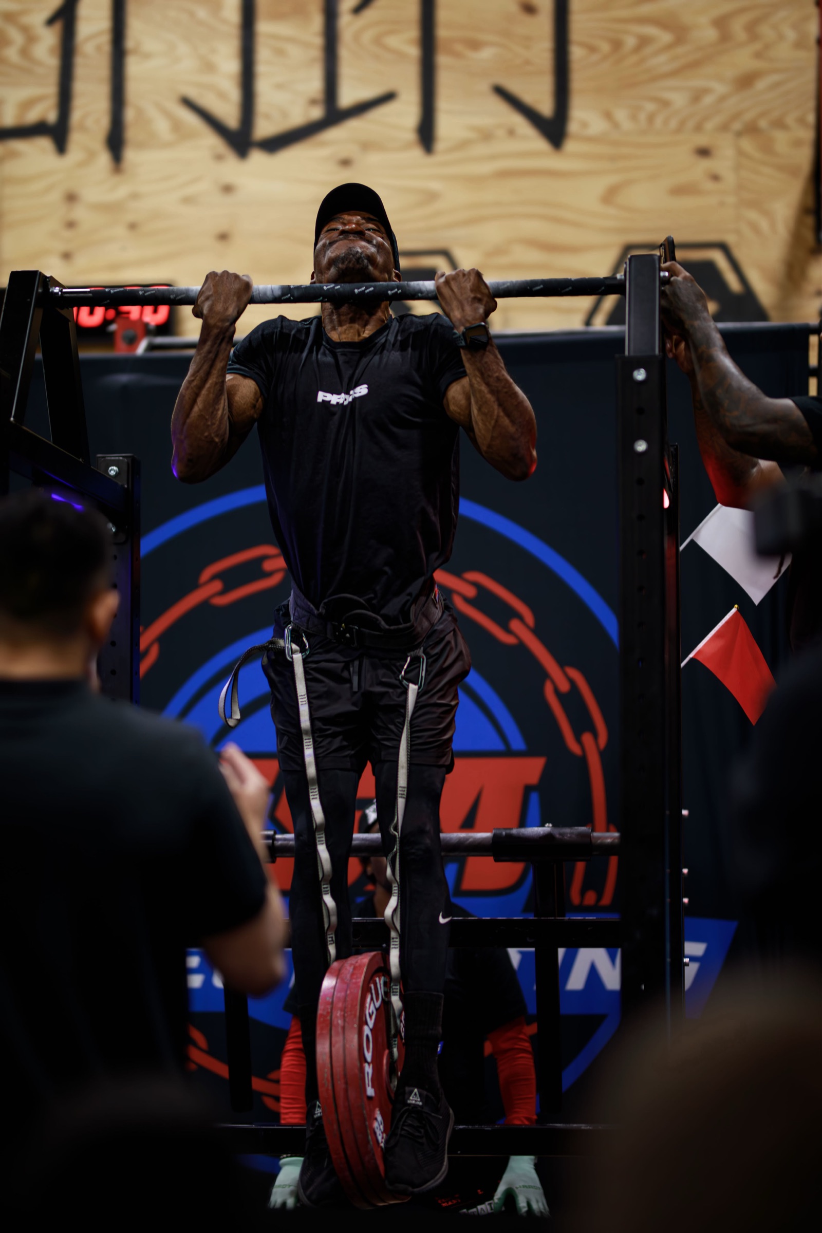 Lincoln Black completing a weighted pull-up at a Streetlifting competition with weight plates suspended from his belt